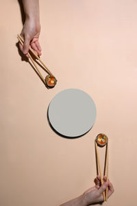 Midsection of woman holding ice cream against gray background