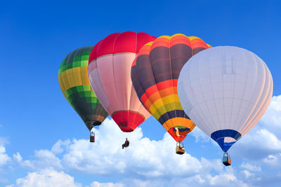 Low angle view of hot air balloons against blue sky