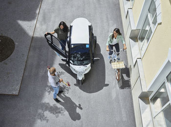 Three people with electric bubble car, skateboard and bicycle