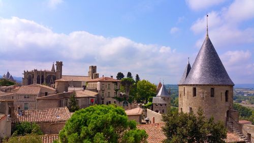 Castle by houses at carcassonne against sky