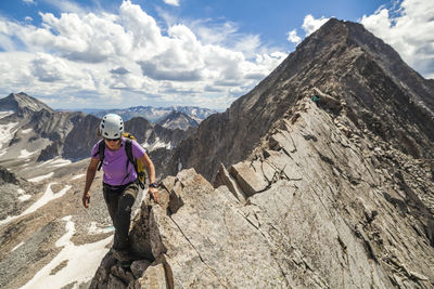 Women climb narrow ridge on capitol peak, elk mountains, colorado