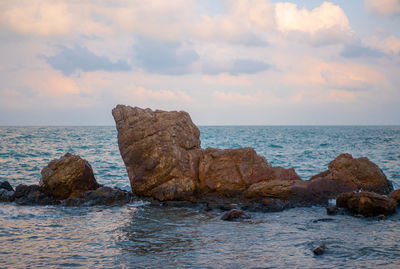 Rocks on sea shore against sky