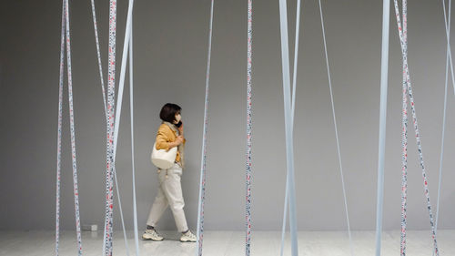 Rear view of woman standing against wall