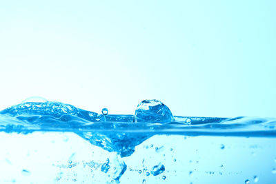 Close-up of water splashing against blue background