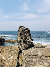 Scenic view of rocks on beach against sky