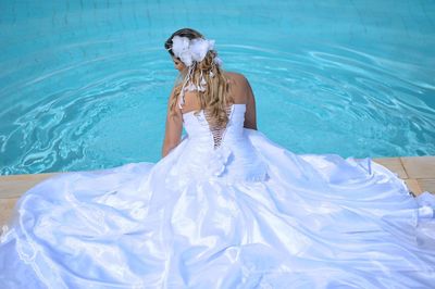 Rear view of woman standing in swimming pool