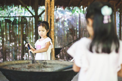 Girls mixing animal dung in container at workshop