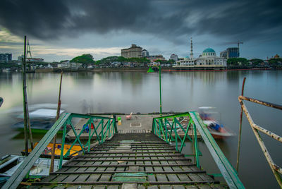 View of pier on water against cloudy sky