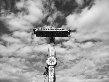 Low angle view of amusement park ride against cloudy sky