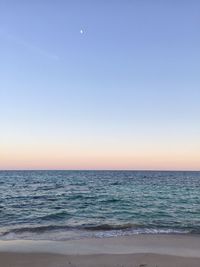 Scenic view of beach against sky at dusk