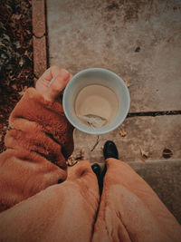 Low section of man holding coffee cup