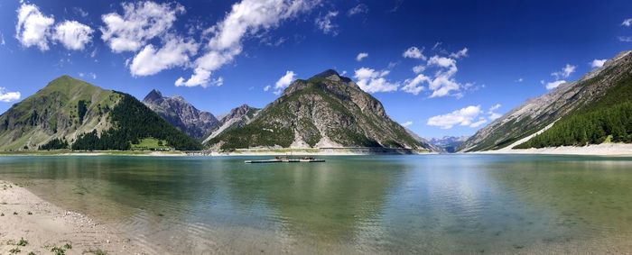 Panoramic view of lake and mountains against blue sky