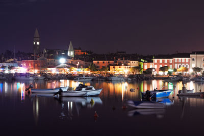 Boats moored in river at night