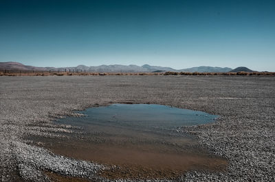 Scenic view of desert against clear blue sky