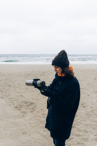 Portrait of happy smiling woman walking outdoor in the sea shore beach on wind weather. person