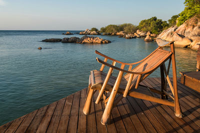 Deck chair at resort patio by sea with stone arch and sea view , ko man klang, rayong, thailand. 