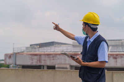 Side view of man standing against sky