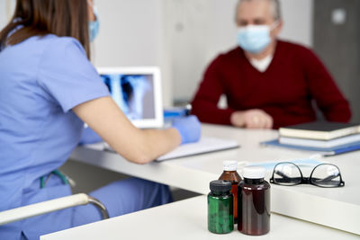 Midsection of female doctor talking with patient