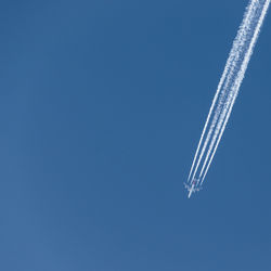 Low angle view of vapor trail in blue sky