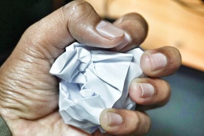 Close-up of human hand holding paper