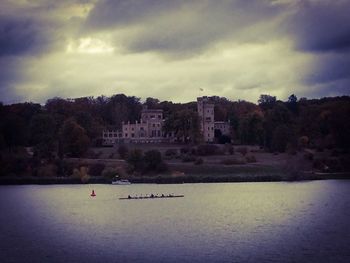 Scenic view of lake by buildings against sky