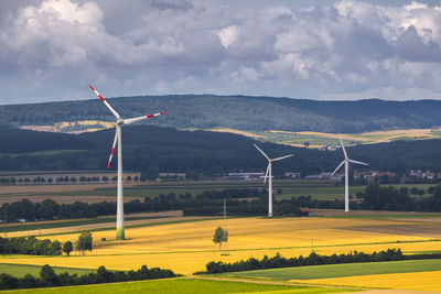 Traditional windmill on field against sky