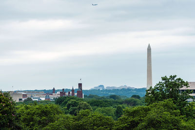 Buildings in city against cloudy sky