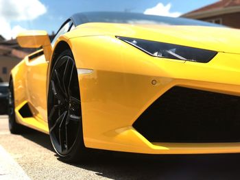 Close-up of yellow car on road