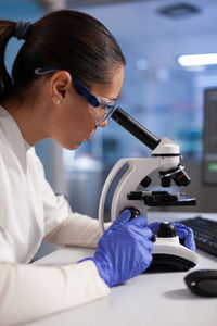 Scientist using microscope at lab