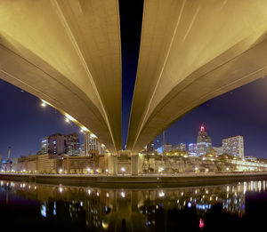 Illuminated bridge over river at night