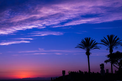 Silhouette palm trees against sky at sunset