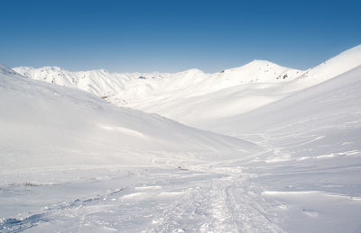 Scenic view of snowcapped mountains against blue sky