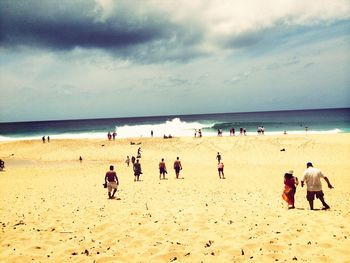 People at beach against sky