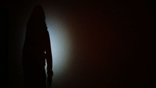 Silhouette of woman in darkroom