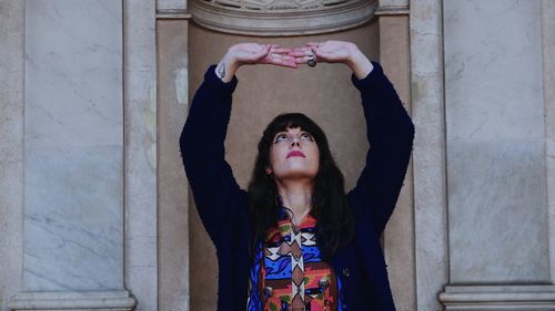 Portrait of woman standing against wall