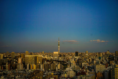 Modern buildings in city against blue sky