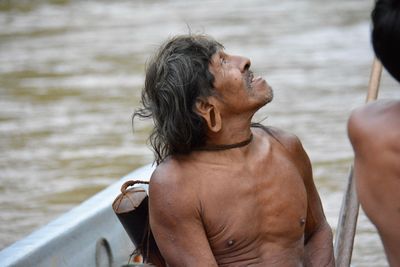 Midsection of shirtless man in sea