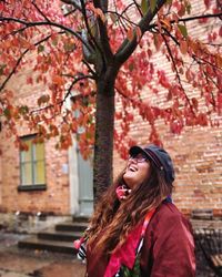 Smiling woman standing outdoors during autumn