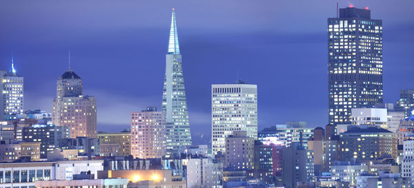 Illuminated buildings against sky at night
