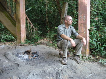 Full length of man sitting at forest