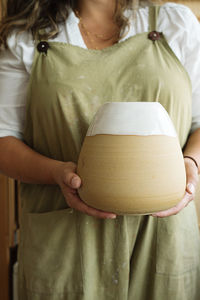 Midsection of woman holding ceramic in workshop