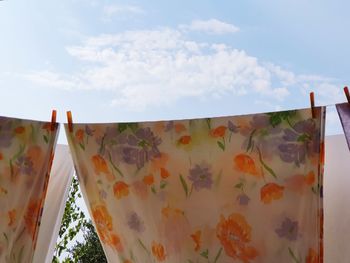 Low angle view of clothes drying on clothesline against sky