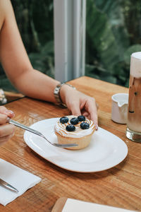 Midsection of woman having breakfast on table