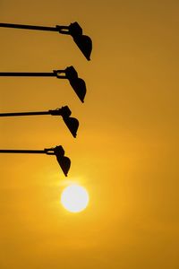Low angle view of silhouette sun against clear sky during sunset