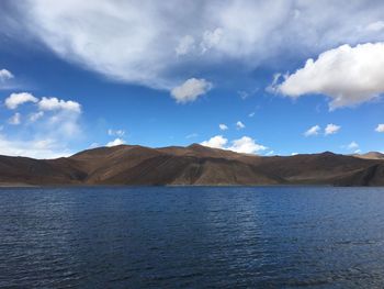 Scenic view of lake by mountains against sky