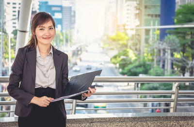 Portrait of young woman working in city