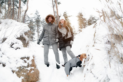 Woman standing on snow covered trees during winter