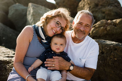 Grandparents holding & hugging grandson