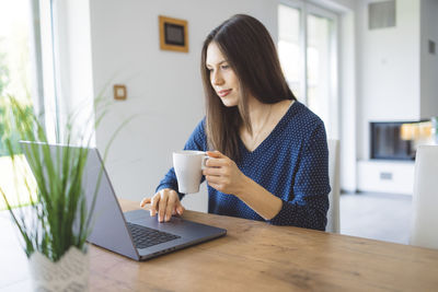 Young woman using laptop at home