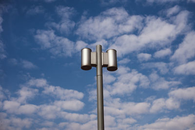 Low angle view of pole against cloudy sky